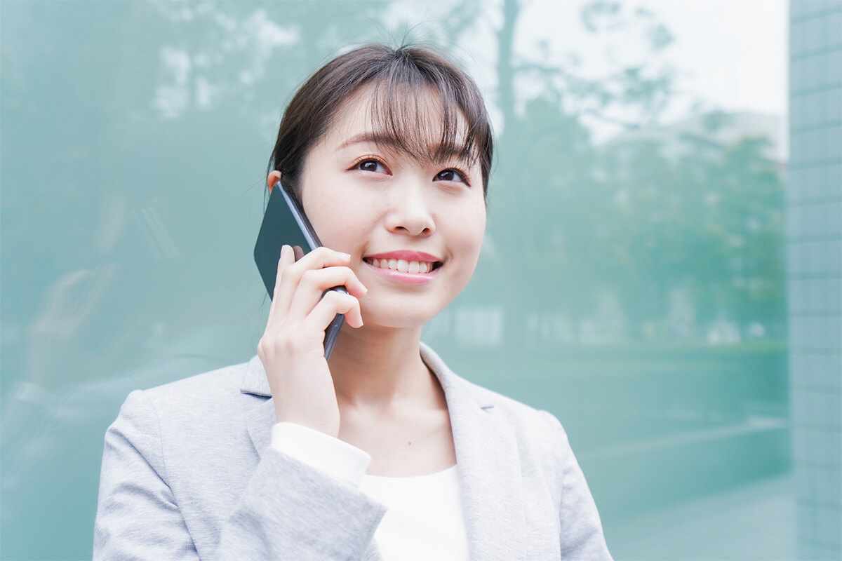 27783191_m 笑顔でスマホで会話する女性